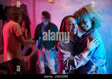 Lächelnde, glückliche, weibliche Freunde, die auf einer Party tanzen Stockfoto