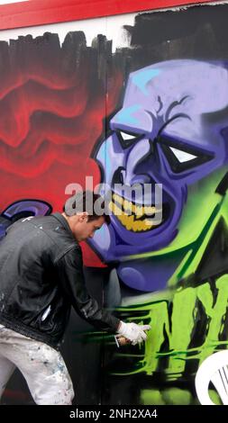 Graffiti-Show in Bacon St London E2. Künstler arbeitet auf der Baustelle und hording Teil des Wochenend-Projekt. Stockfoto