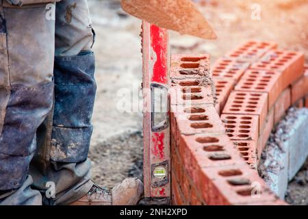 Maurer arbeiten an einer gebogenen Wand Stockfoto