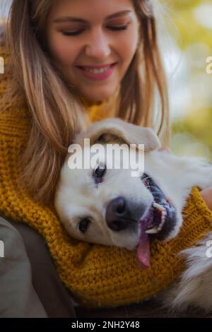 Belgrad, Serbien. 10. November 2022. Eine Frau, die an einem schönen sonnigen Tag mit ihrem süßen goldenen Retriever in einem Park spaziert. Stockfoto