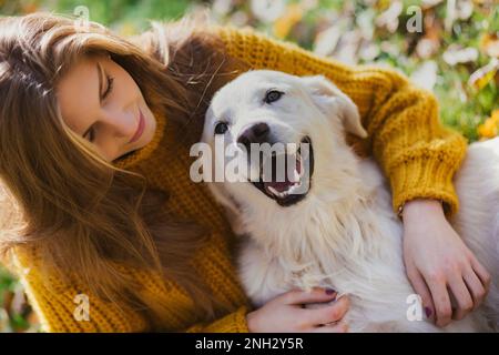 Belgrad, Serbien. 10. November 2022. Junge, schöne Frau, die ihren goldenen Retriever anschaut und an einem sonnigen Tag im Park Spaß hat. Stockfoto