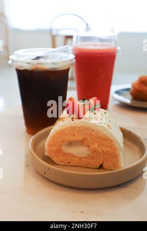 Brötchen, Kuchenbrötchen oder Schweizer Brötchen mit Erdbeergeschmack und Kaffee und ErdbeerSmoothie Stockfoto