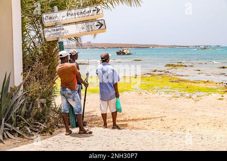 Drei Männer am Hafen von Sal Rei schauen auf den Atlantischen Ozean, Boa Vista, Kap Verde Inseln Stockfoto