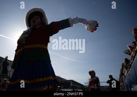 Mainz, Deutschland. 20. Februar 2023. Während der Shrove-Montags-Parade in Mainz winkt ein Tänzer mit einem Blumenstrauß. Das Motto der Prozession lautet: "In Mainz steht Shrovetide voll und ganz für Frieden, Freiheit, Toleranz!" Aufgrund der Corona-Pandemie findet sie zum ersten Mal seit zwei Jahren statt. Kredit: Sebastian Christoph Gollnow/dpa/Alamy Live News Stockfoto