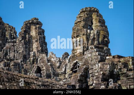 Riesige, in den Stein geschnitzte Gesichter auf dem alten Bayon-Tempel in Angkor Thom in Angkor in Kambodscha. Stockfoto