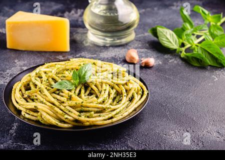 Nudelspaghetti mit Pesto-Sauce und frischen Basilikumblättern, selektiver Fokus Stockfoto