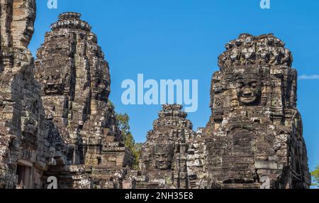 Riesige, in Fels geschnitzte Gesichter im alten Bayon-Tempel in Angkor Thom in Angkor in Kambodscha. Stockfoto