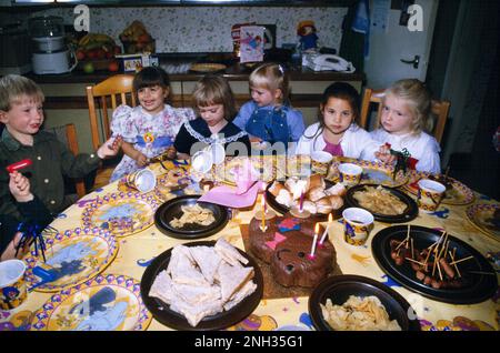 Kinder Sitzen Am Tisch Und Feiern Den 5-Jährigen Geburtstag Von Surrey England Stockfoto