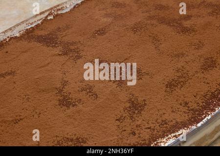 Nahaufnahme der cremigen Textur der ersten Kakaolage in einem köstlichen und gesunden hausgemachten Tiramisu-Dessert. Köstliche Idee. Stockfoto