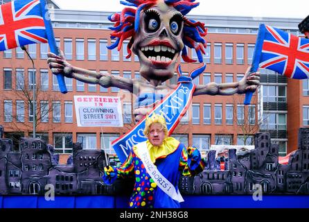 Rosenmontags-Prozession in Düsseldorf; Themenfloß von Jaques Tilly: Karnivalist mit Boris Johnson Maske vor dem Brexit Floß. Stockfoto