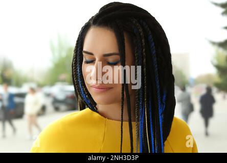 Schöne junge Frau mit Nasenlöchern und Dreadlocks draußen Stockfoto