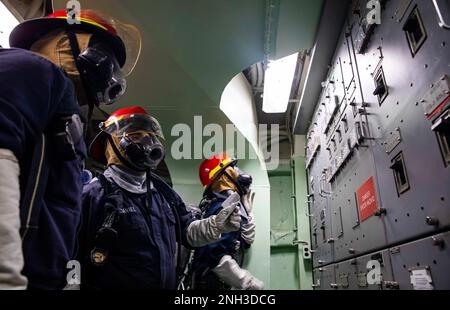 221209-N-XK047-1034 CELEBES SEA (9. Dez. 2022) – Seeleute finden Leistungsschalter in einem Lastzentrum während einer allgemeinen Quartierübung an Bord des Amphibienschiffs USS Makin Island (LHD 8), 9. Dez. 2022. Seeleute müssen die entsprechenden Trennschalter finden, um Räume elektrisch zu isolieren und so Unfälle an Bord zu vermeiden. Die Makin Island Amphibious Ready Group, bestehend aus dem Amphibienschiff USS Makin Island (LHD 8) und der Amphibienladerampe USS Anchorage (LPD 23) und der USS John P. Murtha (LPD 26), ist im US-Flottengebiet 7. mit der einschifften 13. Marine Ex tätig Stockfoto