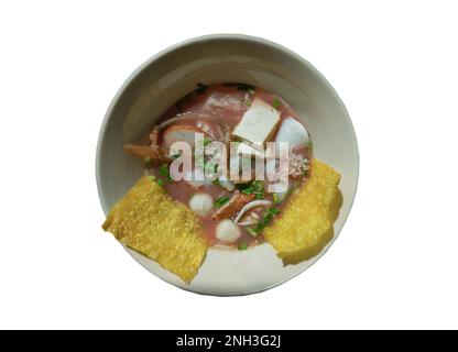 Yentafo Eiernudeln Suppe mit rosa Sauce und Fischbällchen, Garnelen, frischer Tintenfisch, frischer Tintenfisch, eingelegter Tintenfisch, Quallen, Tofu und gebratene Wontons mit Witz Stockfoto