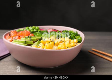 Köstlicher Salat mit Lachs und Gemüse auf einem Holztisch Stockfoto