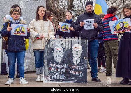 London, Großbritannien. 20. Februar 2023. Demonstranten halten während der Demonstration zur Unterstützung von Micheil Saakaschwili auf dem Parlamentsplatz Schilder mit dem Titel "Save Misha" und ein Schild mit Kritikpunkten gegenüber dem ehemaligen georgischen Ministerpräsidenten Bidzina Ivanischwili und Wladimir Putin. Der ehemalige georgische Präsident und Gouverneur des Oblast Odesa in der Ukraine verbüßt derzeit eine Gefängnisstrafe in Georgien wegen Machtmissbrauchs, und seine Gesundheit soll sich verschlechtern. Kredit: SOPA Images Limited/Alamy Live News Stockfoto