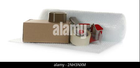 Luftpolsterrolle, Karton und Klebebandabroller auf weißem Hintergrund Stockfoto