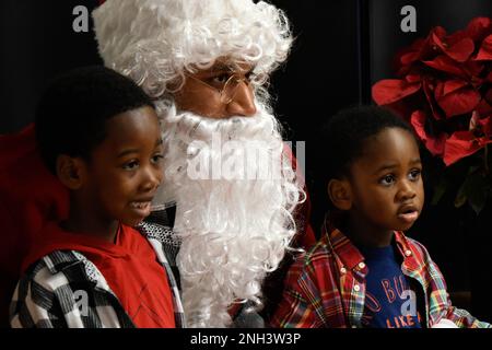 Studenten posieren mit dem Weihnachtsmann für Fotos im Charlotte, N.C. Aristotole Preparatory Academy, 10. Dezember 2022. Die jährliche Veranstaltung, Operation Santa Claus, wird von der North Carolina Air National Guard Chapter 7 Organisation veranstaltet, in dem Bestreben, Aufmunterung zu bringen und eine positive Beziehung mit der lokalen Gemeinschaft zu fördern. Stockfoto