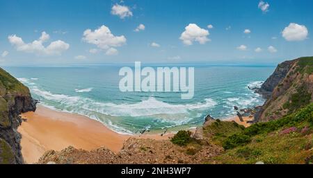 Sandstrand mit felsigen Bergrücken trübes Wetter Aussicht auf Sommer Atlantic an der felsigen Küste (Costa Vicentina, Algarve, Portugal). Und Ocean Surf Wellen. Stockfoto