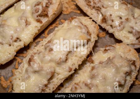 Nahaufnahme von frisch gebackenen Thunfisch-Sandwich-Hälften mit Käse im Backblech Stockfoto