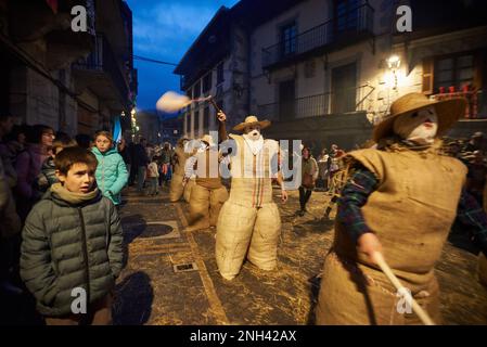 Lesaka, Spanien. 18. Februar 2023. Mehrere „zaku-zaharraks“ beginnen die Tour, indem sie ihre Blasen während des Karnevals von Lesaka bewegen. Der „zaku-zaharrak“ sind typische Figuren des Lesakakaker Karnevals, gefüllt in Säcke voller Stroh mit Gesichtern bedeckt mit Schals, die aufgeblasene Blasen tragen, um die Menschen zu treffen, die bei Sonnenuntergang durch die Straßen der Stadt laufen. Kredit: SOPA Images Limited/Alamy Live News Stockfoto