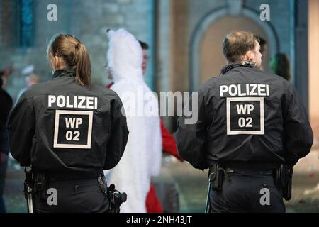 Mainz, Deutschland. 20. Februar 2023. Polizisten stehen nach der Shrove-Montags-Parade in der Stadt. Das Motto der Prozession lautete: "In Mainz steht Shrovetide voll und ganz für Frieden, Freiheit, Toleranz!" Aufgrund der Corona-Pandemie fand sie zum ersten Mal seit zwei Jahren statt. Kredit: Sebastian Christoph Gollnow/dpa/Alamy Live News Stockfoto