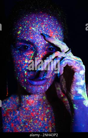 Modemodell Frau in Neonlicht, Porträt eines wunderschönen Modells mit fluoreszierendem Make-up, künstlerisches Design von Disco-Tänzern, die im UV-Licht posieren, farbenfrohes Design Stockfoto