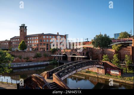 Das Narrowboat liegt auf dem Bridgewater Canal in Deansgate vor einer blauen Skyline vom Castle Field Basin, Manchester, Nordwestengland Stockfoto