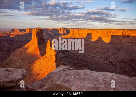 Die Crow's Head Spires am Marlboro Point werfen einen Batman-ähnlichen Schatten im Shafer Canyon bei Moab, Utah. Stockfoto