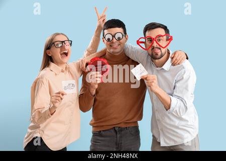 Geschäftskollegen in lustiger Verkleidung auf blauem Hintergrund. Feier zum 1. April Stockfoto
