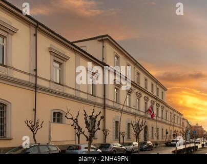 Savigliano, Italien - 16. Februar 2023: Institut für Hochschulbildung I.I.S. Cravetta-Marconi, Highschool-Gebäude in der Via Roma 70 mit Sonnenuntergang am Himmel Stockfoto