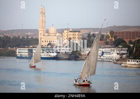 Felukken oder traditionelle Segelboote auf dem Nil, mit der El Tabia Moschee im Hintergrund, Assuan, Ägypten Stockfoto