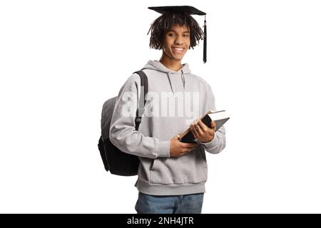 afroamerikanischer Student mit einem Abschlussmütze, der Bücher hält und isoliert auf weißem Hintergrund lächelt Stockfoto