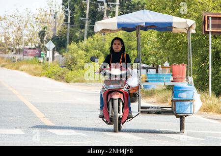 BANGKOK, THAILAND, FEBRUAR 07 2023, Ein Papaya-Salatverkäufer mit einem mobilen Kiosk fährt die Straße hinunter Stockfoto