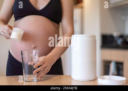 Schwangere Frau hält eine Schaufel mit Molke Stockfoto