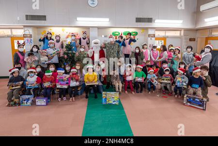 221213-N-VI040-1209 AYASE, Japan (13. Dezember 2022) LT. Jonathan D. Rozendaal, Naval Air Facility (NAF) Atsugi, japanischer Befehlskaplan, Religionsspezialist 1. Klasse Kassandra Castaneda, und Master-at-Arms 1. Klasse Matthew Fumbanks, verkleidet als Weihnachtsmann, posieren für ein Foto mit Kindern und Personal der Mominoki-en Schule für Behinderte in Ayase, Japan, 13. Dezember 2022. Die Atsugi-Kapelle der NAF, die Kapelle des guten Hirten, besucht Mominoki-en mit dem Weihnachtsmann, um Geschenke zu überbringen, die von der NAF Atsugi-Gemeinde im Geiste der Weihnachten seit über 35 Jahren gespendet werden. Stockfoto
