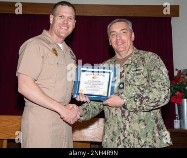 Cmdr. Douglas Kennedy, Chief Staff Officer des Commander, Fleet Activities Sasebo (CFAS), stellt Leutnant j.g. vor Zachery Bixby, Assistant Security Officer der CFAS, mit dem Abzeichen des Navy Security Force Officers während einer Qualifikationszeremonie am 13. Dezember 2022 bei der CFAS. Seit 75 Jahren stellt die CFAS Basiseinrichtungen und -Dienste bereit, wartet und betreibt diese, um die US- und alliierten Streitkräfte zu unterstützen und gleichzeitig ihre Familien und die Gemeinschaft optimal zu unterstützen. Stockfoto