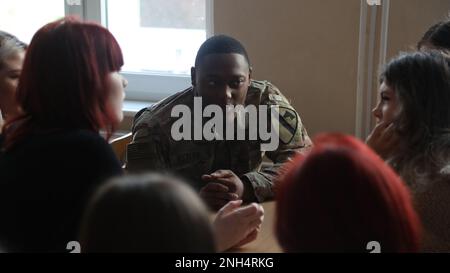 Greywolf Trooper, SPC. Chansylor Butler, Hauptquartier und Hauptquartier, 215. Brigaden-Stützbataillon, 3. Panzerbrigade-Kampfteam, 1. Kavallerieabteilung, interagiert mit polnischen Schülern der Kalige High School, 9. Dezember 2022. Ereignisse wie diese stärken weiterhin die Bande zwischen der polnischen Gemeinschaft und der US-Armee. Stockfoto