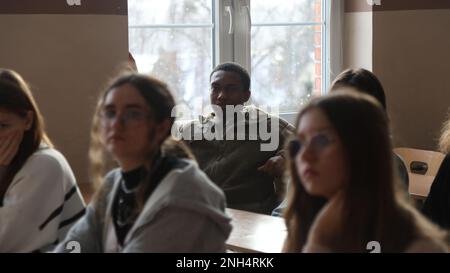 Greywolf Trooper, SPC. Tyrell Kinley, Headquarters and Headquarters Company, 215. Brigaden-Stützbataillon, 3. Panzerbrigade-Kampfteam, 1. Kavallerieabteilung, interagiert mit polnischen Schülern der Kalige High School, 9. Dezember 2022. Ereignisse wie diese stärken weiterhin die Bande zwischen der polnischen Gemeinschaft und der US-Armee. Stockfoto