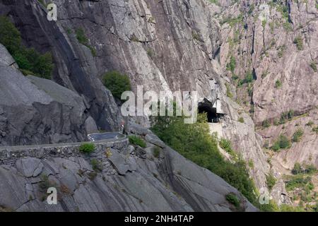 Serpentine Bergstraße in steilem, felsigen Berggelände. Tunnel rechts. Stockfoto