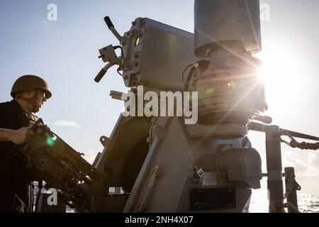 221213-N-YV347-1164 PAZIFIK (13. DEZEMBER 2022) USA Navy Gunner's Mate 3. Class James Ingebretson aus Seabeck, Washington, wartet das MK 38 25 mm Maschinengewehr während einer Feuerübung an Bord des Ticonderoga-Klasse-Guided-Raketenkreuzers USS Bunker Hill (CG 52). Bunker Hill, Teil der Nimitz Carrier Strike Group, führt derzeit Routinevorgänge durch. Stockfoto