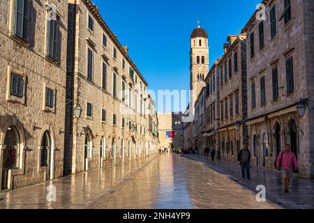 Am frühen Morgen auf der Stradun (Placa), mit Glockenturm der Franziskanerkirche auf der rechten Seite und Pile Gate dahinter, in der Altstadt von Dubrovnik in Kroatien Stockfoto