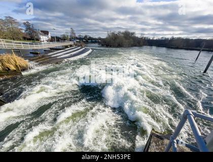 Schnell fließendes weißes Wasser auf der Themse im Hambledon Wehr mit Hambledon Mill in der Ferne nahe Henley-on-Thames, Oxfordshire, England, Großbritannien Stockfoto