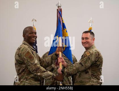 Major David Ratté übernimmt das Kommando über das 436. Sicherheitsgeschwader, nachdem er den Guidon von Oberst Phelemon Williams, Left, 436. Befehlshaber der Mission Support Group, während einer Zeremonie zum Kommandowechsel am Landing auf der Dover Air Force Base, Delaware, 21. Juni 2022 erhalten hat. Ratté war zuvor Befehlshaber der 768. Expeditionstruppe der Luftwaffe. Stockfoto