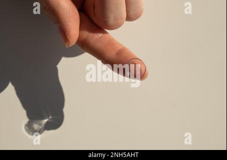 Nahaufnahme einer Kontaktlinse am Zeigefinger einer Frau. Stockfoto