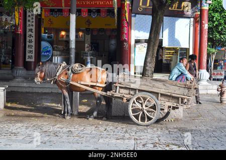 Ein Landsmann, der mit seinem Pferd und seinem Wagen in der Altstadt von Jianshui, Provinz Yunnan, China sitzt Stockfoto