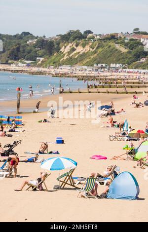 BOURNEMOUTH, Großbritannien - 08. Juli 2022. Sonnenanbeter an einem Sandstrand im Sommer an der Südküste Englands. Bournemouth Beach, Dorset, Großbritannien Stockfoto