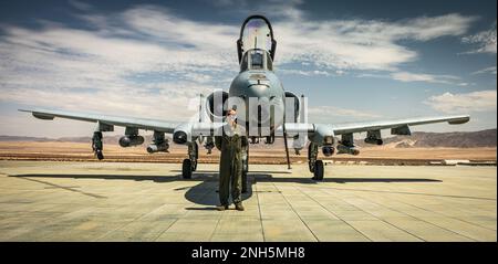 USA Air Force Captain Luke Rockwell, ein A-10 Warthog-Kampfpilot mit dem 357. Kampfgeschwader, 355. Kampfflügel, posiert für ein Foto vor einem A-10 Warthog im Marine Corps Air-Ground Combat Center, Twentynine Palms, Kalifornien, am 18. Juli 2022. Die Piloten der 357. Kampfstaffel landeten in Camp Wilson, um sich für die Landung auf unverbessertem Boden zu qualifizieren, und lieferten Marines von der 473. Marineflügelstaffel einen Einführungsbrief für das Flugzeug. Stockfoto