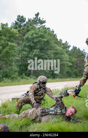 Sgt. William Sievers, Trainer/Trainer für die 4. Multifunktionale Kavallerie-Trainingsbrigade, Right, beobachtet Soldaten der 231. Inland Cargo Truck Company, 377. Sustainment Command, bestimmen die nächste Bewegungsrichtung der Einheit während der Army Warrior Tasks Training im Rahmen der Warrior Übung 78.-22-02. Juli 19, 2022 in Fort McCoy, Wisconsin. Die 78. Training Division wird ab Juli 16-30 in Fort McCoy, Wisconsin, WAREX 78-22-02 durchführen, um die kollektive Bereitschaft der Warfighter aufzubauen und Einheiten für die Ausführung der Mission zur Unterstützung von Unified Land Operations vorzubereiten. Stockfoto