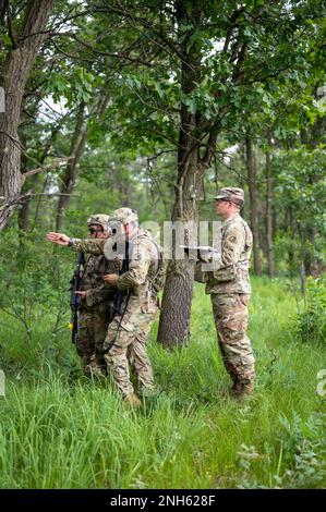 Sgt. William Sievers, Trainer/Trainer für die 4. Multifunktionale Kavallerie-Trainingsbrigade, Right, beobachtet Soldaten der 231. Inland Cargo Truck Company, 377. Sustainment Command, bestimmen die nächste Bewegungsrichtung der Einheit während der Army Warrior Tasks Training im Rahmen der Warrior Übung 78.-22-02. Juli 19, 2022 in Fort McCoy, Wisconsin. Die 78. Training Division wird ab Juli 16-30 in Fort McCoy, Wisconsin, WAREX 78-22-02 durchführen, um die kollektive Bereitschaft der Warfighter aufzubauen und Einheiten für die Ausführung der Mission zur Unterstützung von Unified Land Operations vorzubereiten. Stockfoto