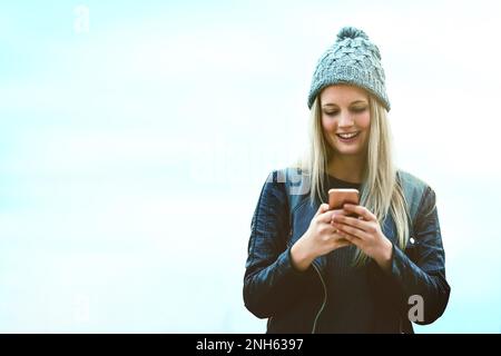 Die intelligentesten Reisenden nutzen die intelligentesten Apps. Eine attraktive junge Frau, die im Freien ein Mobiltelefon benutzt. Stockfoto